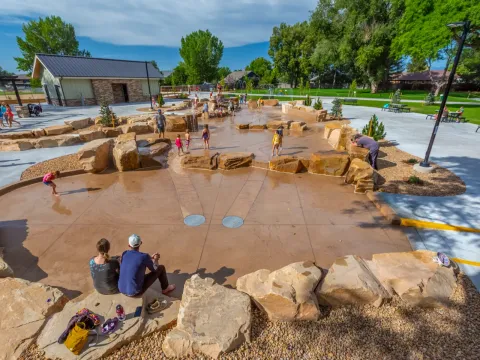 Children playing in Berthoud Town Park's natural-stone water feature.
