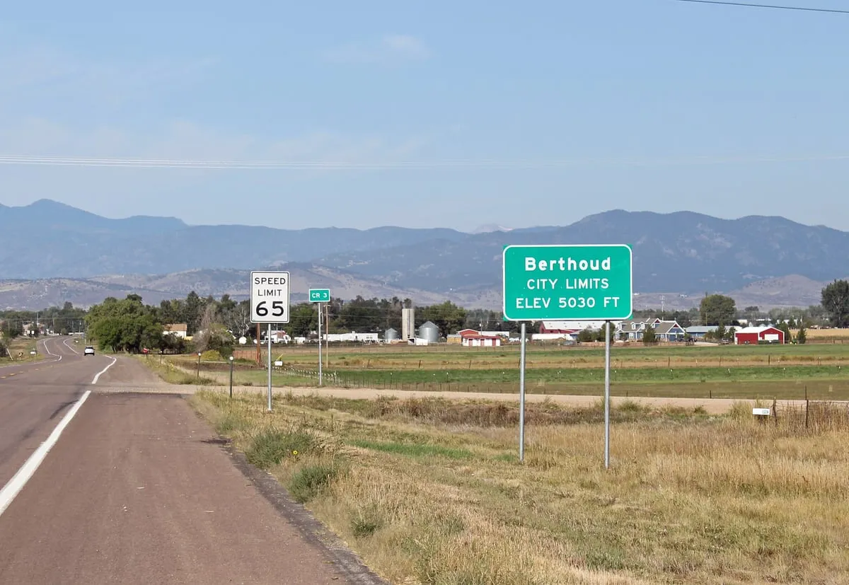 The Berthoud town-limits sign on the road in from the east, with the plains behind it