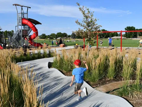 The playground, miniature pump track, swings, and fields at Waggener Farm Park